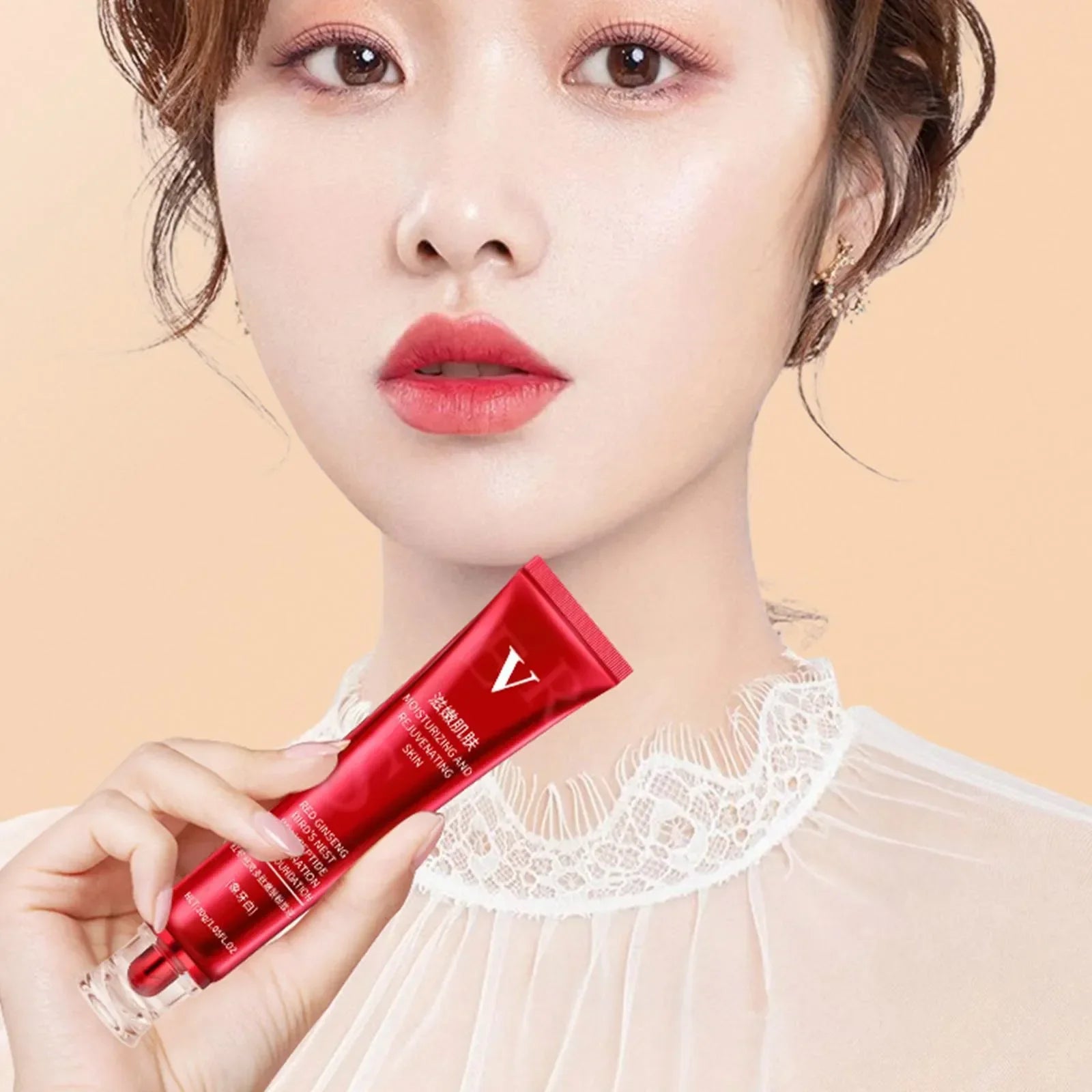 Close-up of a woman with red lipstick holding a red tube of moisturizing and rejuvenating skin cream
