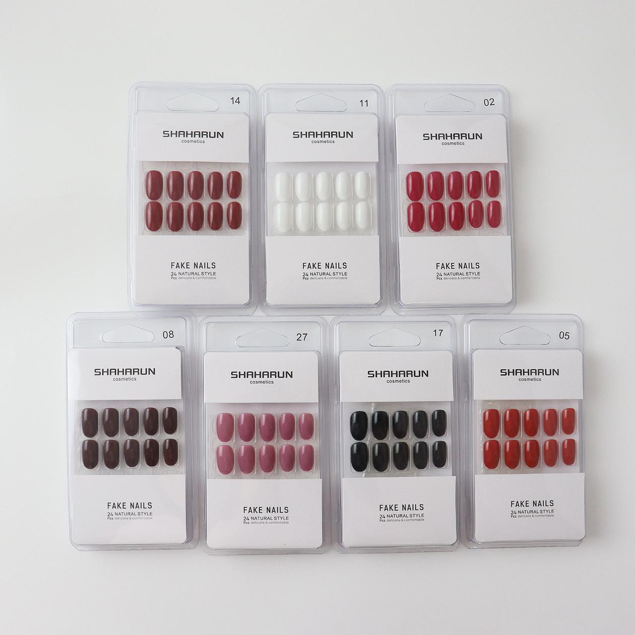 Seven sets of SHAHARUN cosmetics fake nails in various colors including red, white, pink, black, and brown in clear packaging