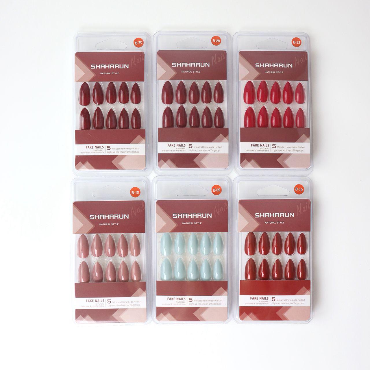 Six packs of SHAHARUN natural style fake nails in various red, pink, and pale blue shades on white background